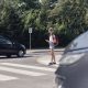 Schoolgirl with headphones and mobile phone on pedestrian crossing